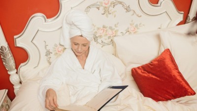 A woman in a robe looking at a menu in bed