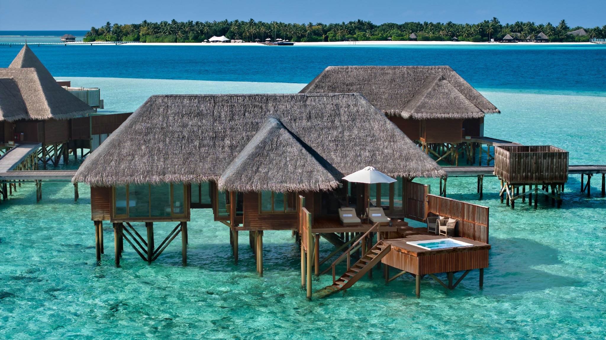 Exterior view of a luxurious Grand Water Villa over the lagoon at Conrad Maldives.