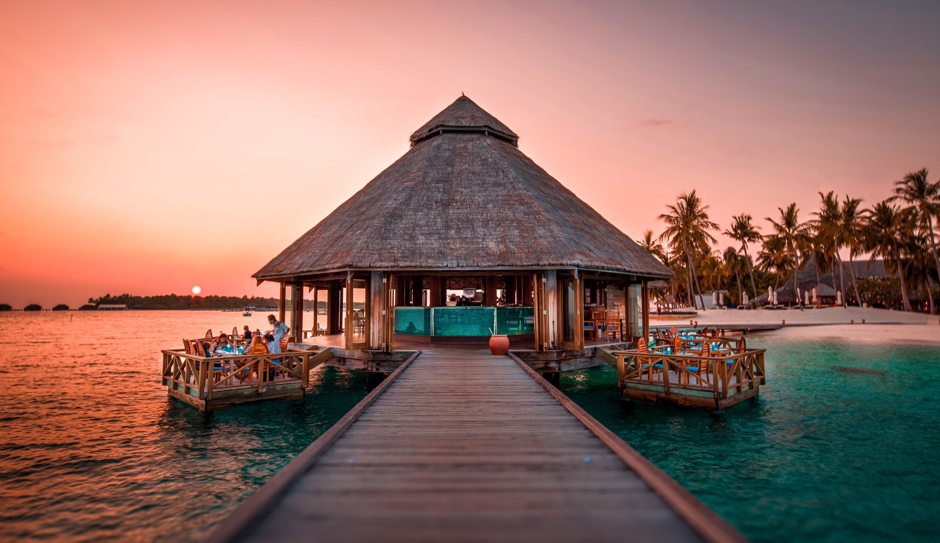Sunset Grill restaurant over the water at golden hour, Conrad Maldives.