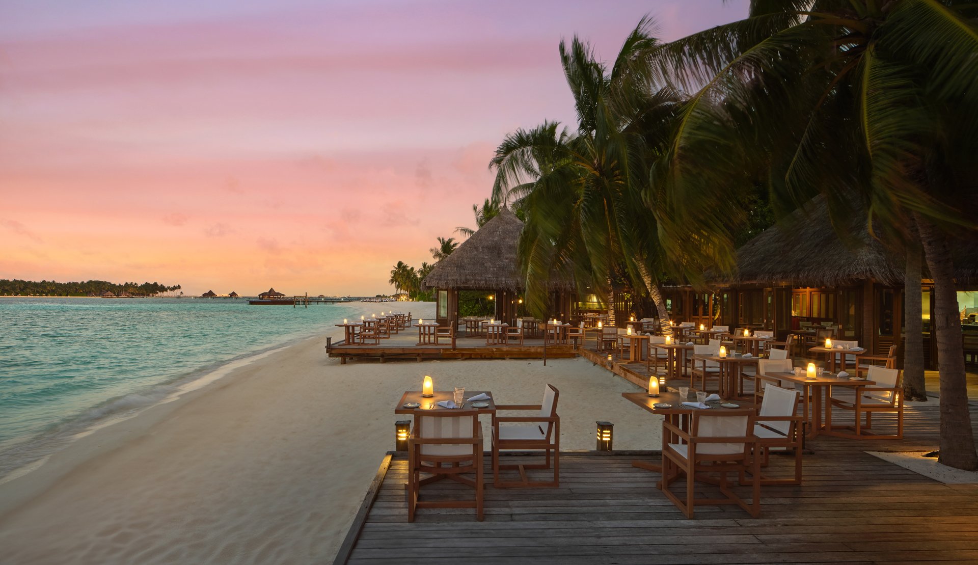 Vilu Restaurant & Bar at sunset with beach seating, Conrad Maldives.