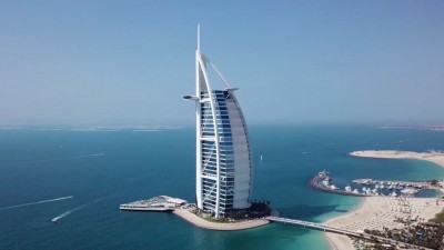 An iconic aerial view of the sail-shaped Jumeirah Burj Al Arab standing on its own island.