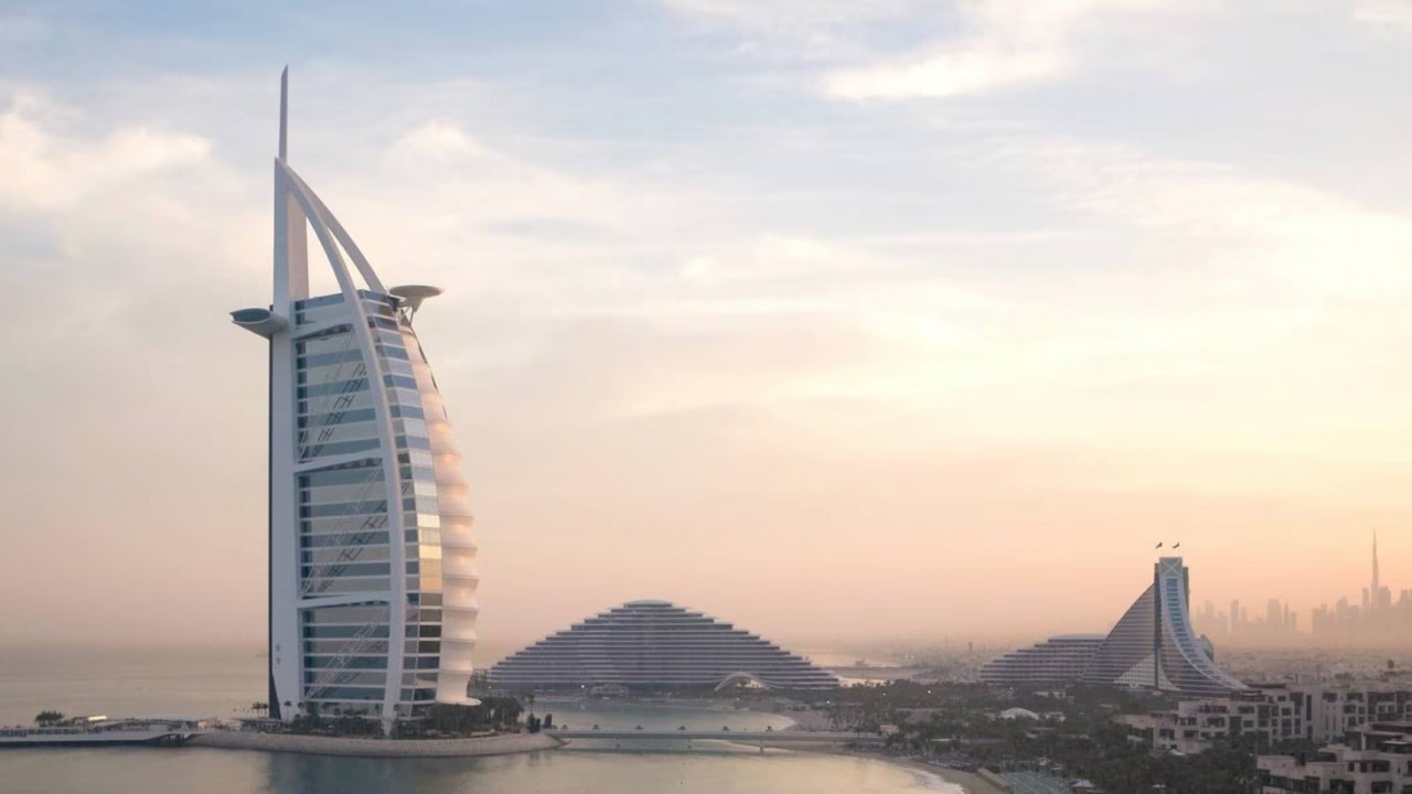 A dramatic drone shot capturing the full scale and beauty of Jumeirah Burj Al Arab on its island.