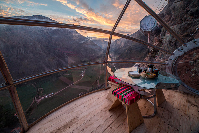 A gourmet dinner with wine being served inside the transparent Skylodge capsule, offering a once-in-a-lifetime dining experience.