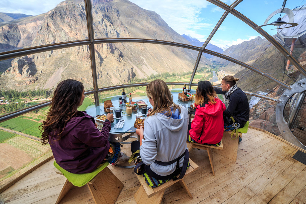 A gourmet dinner with wine being served inside the transparent Skylodge capsule, offering a once-in-a-lifetime dining experience.