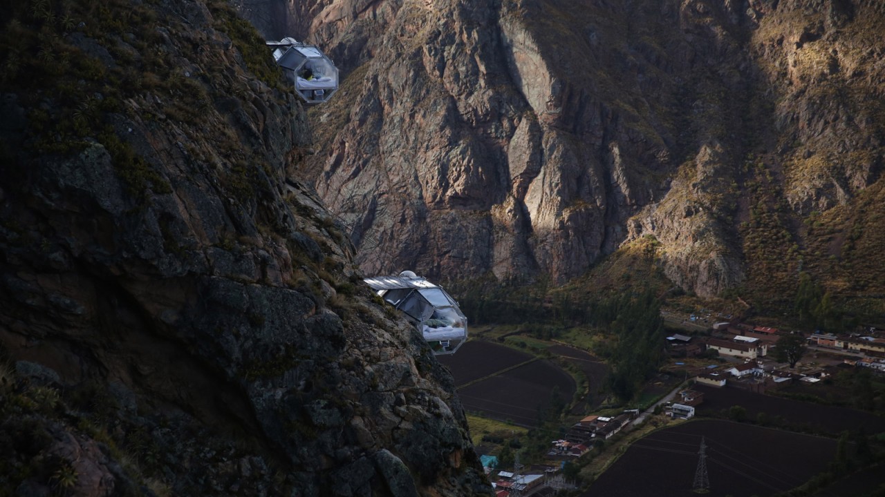 Wide-angle view of two Skylodge capsules suspended 400 meters high with the breathtaking Sacred Valley landscape stretching out behind them.