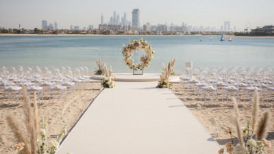 A wedding ceremony setup on the resort's private beach with views of the Arabian Gulf.