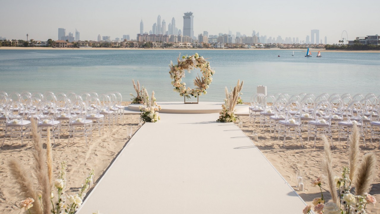 A wedding ceremony setup on the resort's private beach with views of the Arabian Gulf.