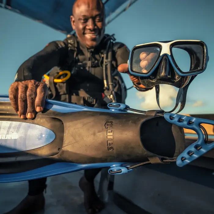 A smiling dive guide at The Manta Resort, ready for a scuba diving adventure in the pristine waters of the Pemba Channel.