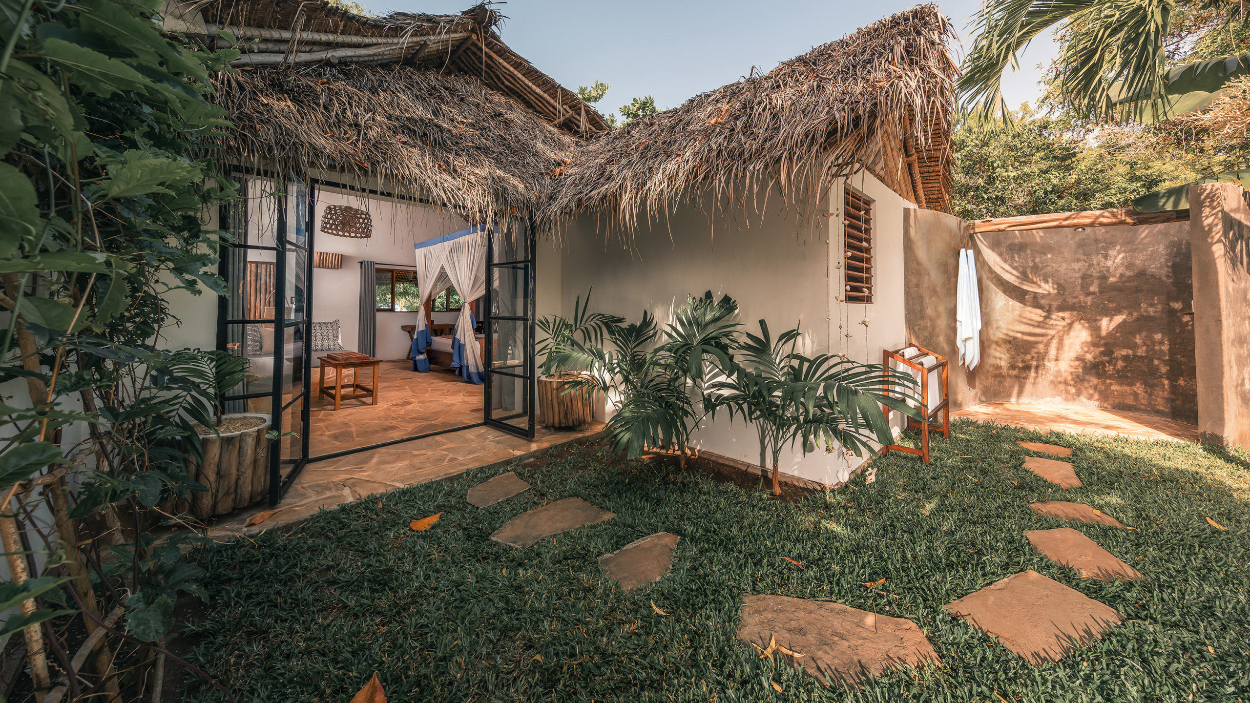 Exterior of a Superior Garden Room at The Manta Resort, nestled in tropical gardens with a private veranda for relaxation.