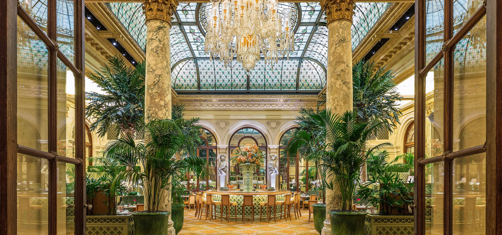 The Palm Court at The Plaza Hotel, featuring its iconic stained-glass dome and afternoon tea service.