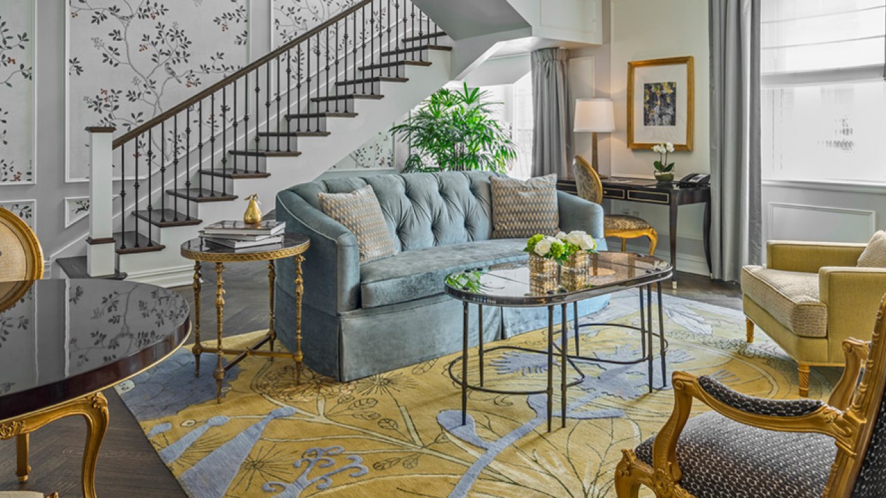 The luxurious living room in the Penthouse One Bedroom Suite, with duplex styling and terrace access.