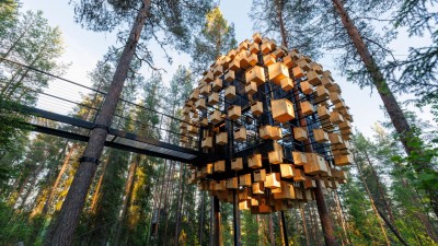 The Biosphere treeroom at Treehotel Sweden, designed by BIG, featuring a facade covered with bird houses amidst the pine forest.
