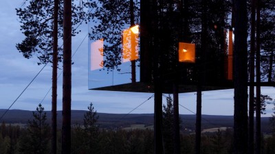 The Mirrorcube at Treehotel Sweden, a reflective treehouse camouflaged in the forest, designed by Tham & Videgård.