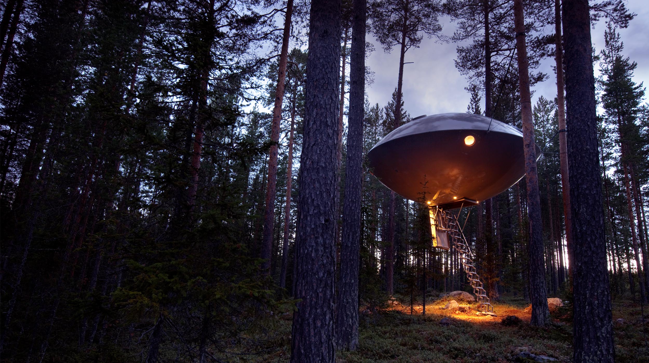 The UFO treehouse at Treehotel Sweden, suspended among the trees for a unique space-themed adventure.
