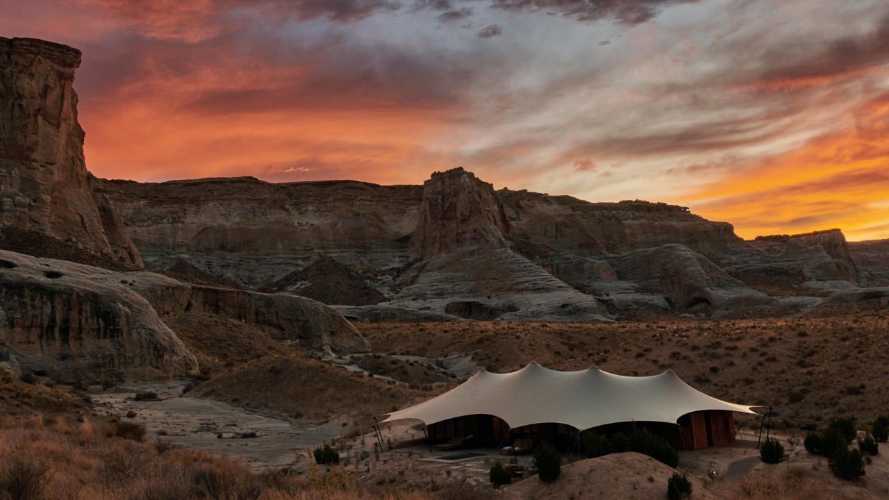 A luxury tented pavilion at Camp Sarika during a beautiful desert sunset.