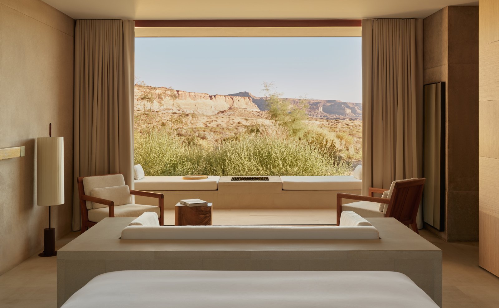 The serene bedroom of a Desert Suite at Amangiri, offering panoramic desert plateau views.