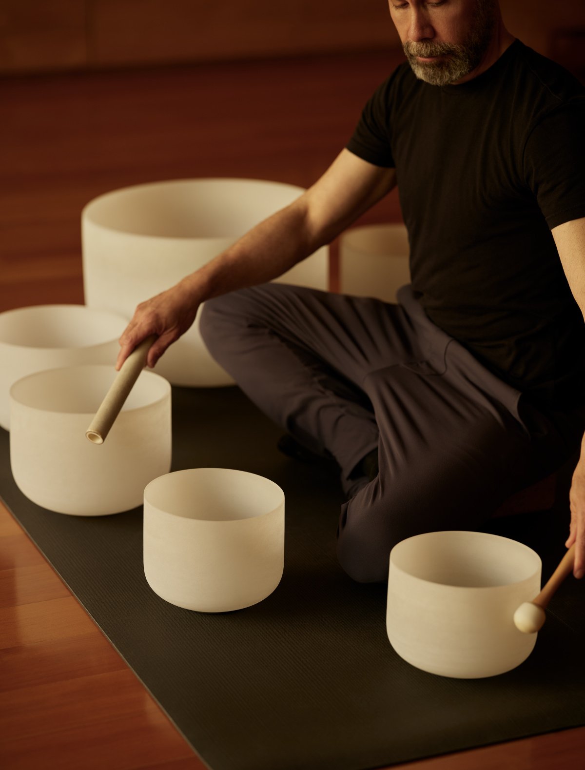 A therapist performing a Sound Bowl Therapy session to promote deep relaxation and euphoria.