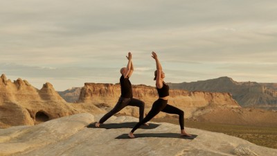 Guests participating in a Yoga on the Rocks session atop a desert mesa with a guide.