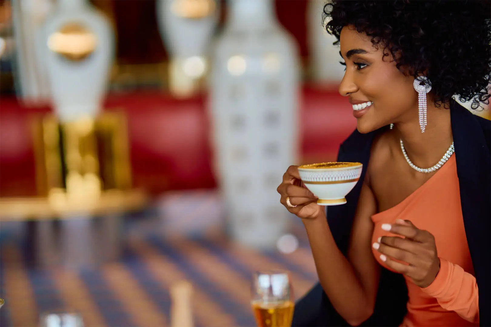 A guest enjoying beverages in the spectacular atrium of Sahn Eddar at Burj Al Arab.