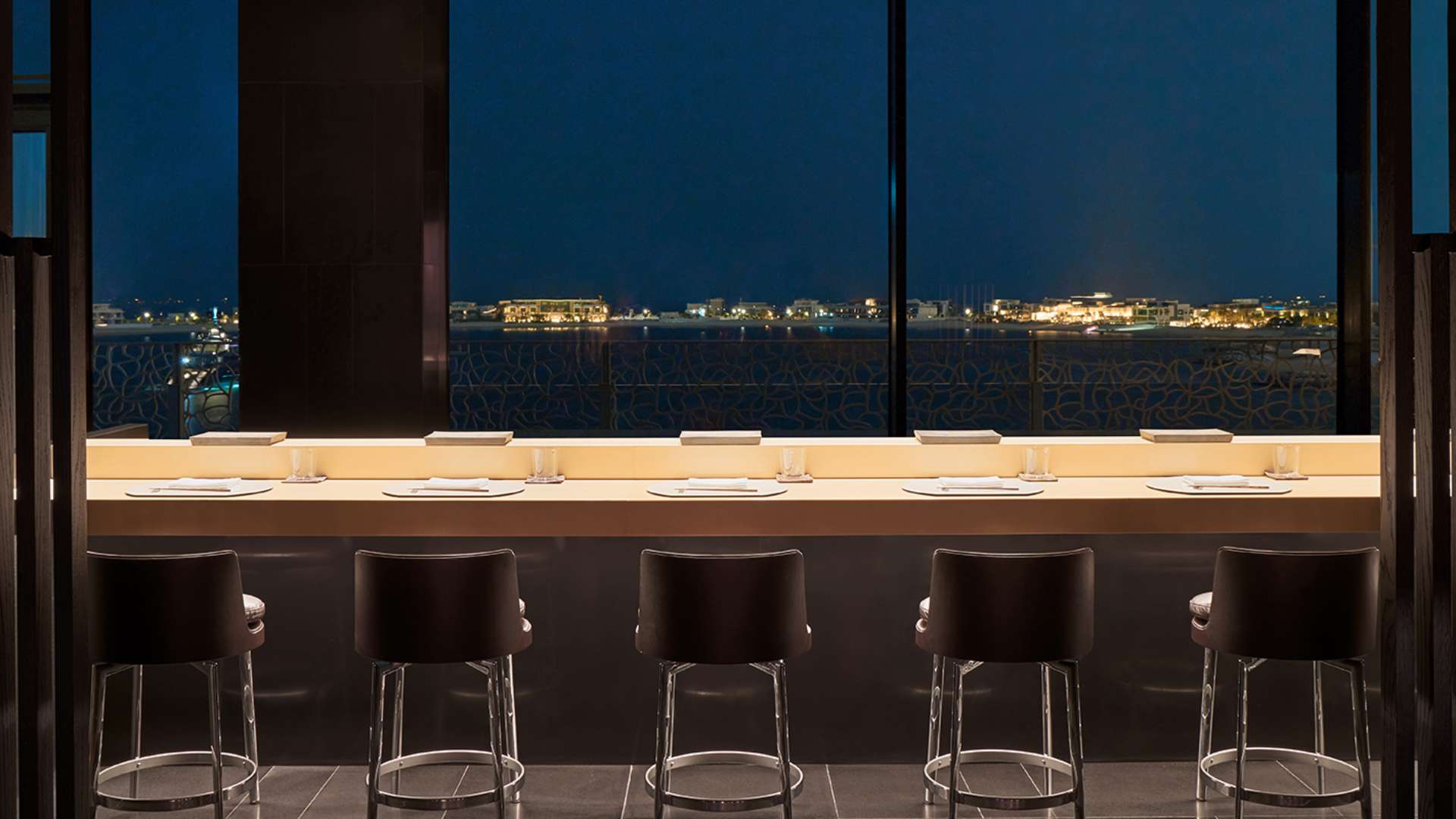 The intimate interior of Hōseki, featuring its exclusive nine-seat omakase counter with Dubai skyline views.