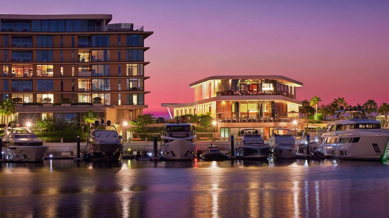 The world's first Bvlgari Yacht Club & Marina at sunset, featuring luxury yachts against the resort's seahorse-shaped island backdrop.