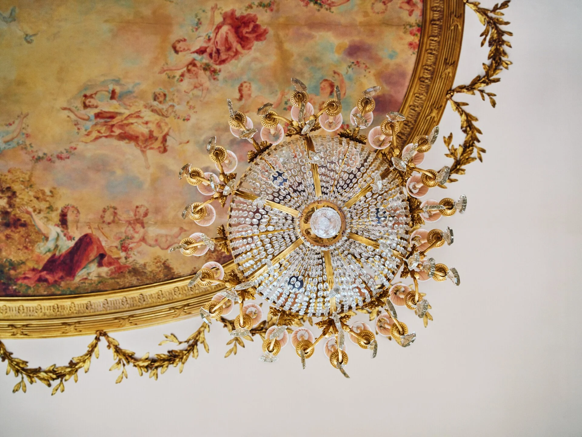 The ornate painted ceiling and grand chandelier in Restaurant le Meurice Alain Ducasse.