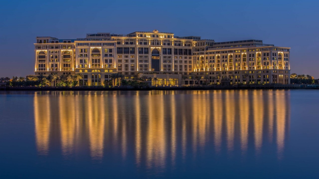 The magnificent neoclassical exterior of Palazzo Versace Dubai illuminated at night.
