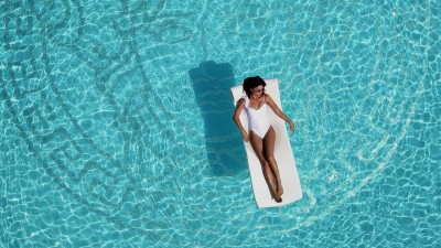 A guest relaxes on a floating aqua bed in one of the hotel's stunning swimming pools.