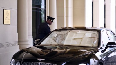A valet attendant warmly welcomes a guest at the grand entrance of Palazzo Versace Dubai.