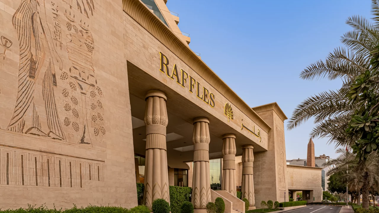 The grand entrance of Raffles Dubai, featuring columns with Egyptian hieroglyphic details.
