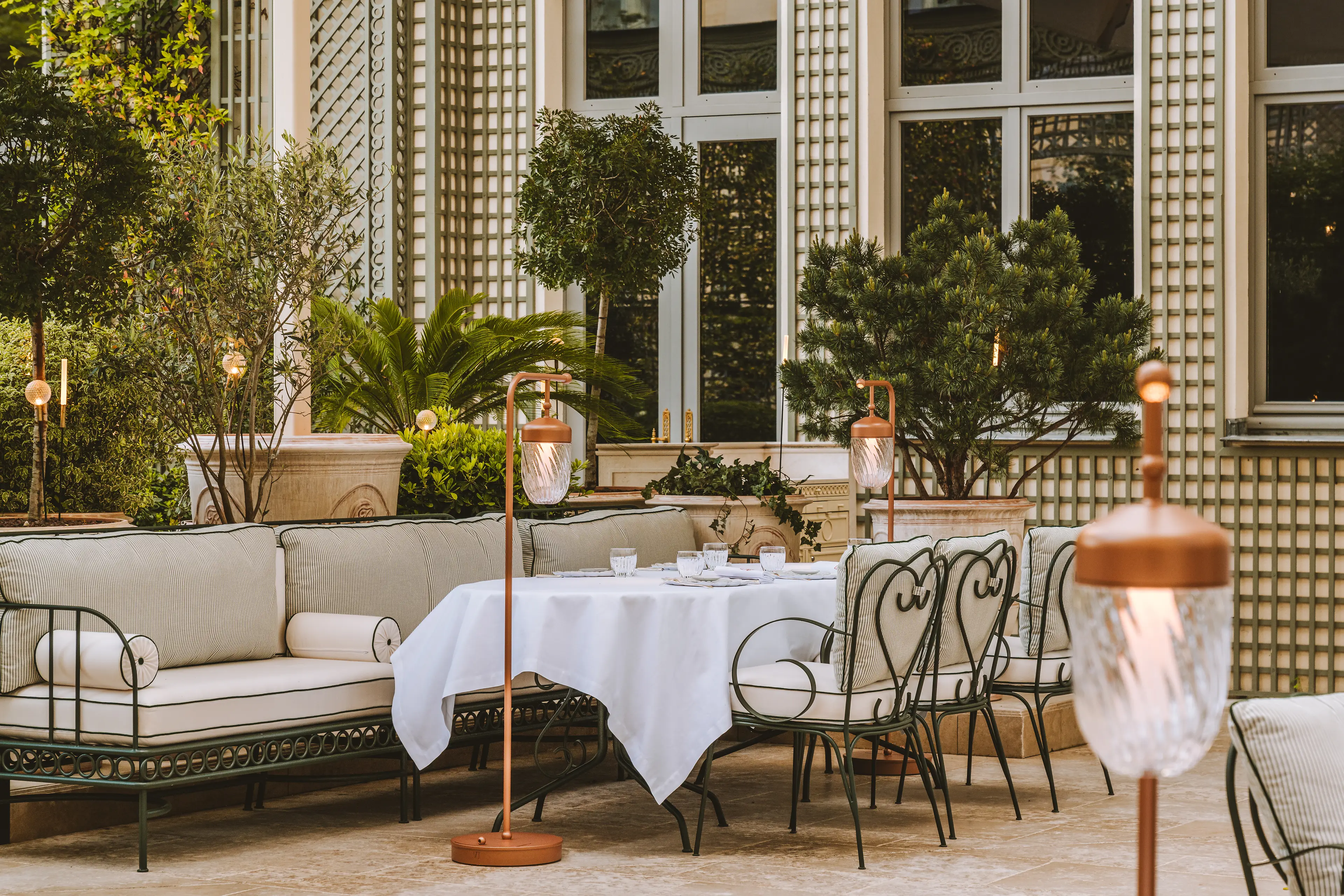 Dining on the tree-lined terrace of Espadon restaurant, overlooking the Grand Jardin.