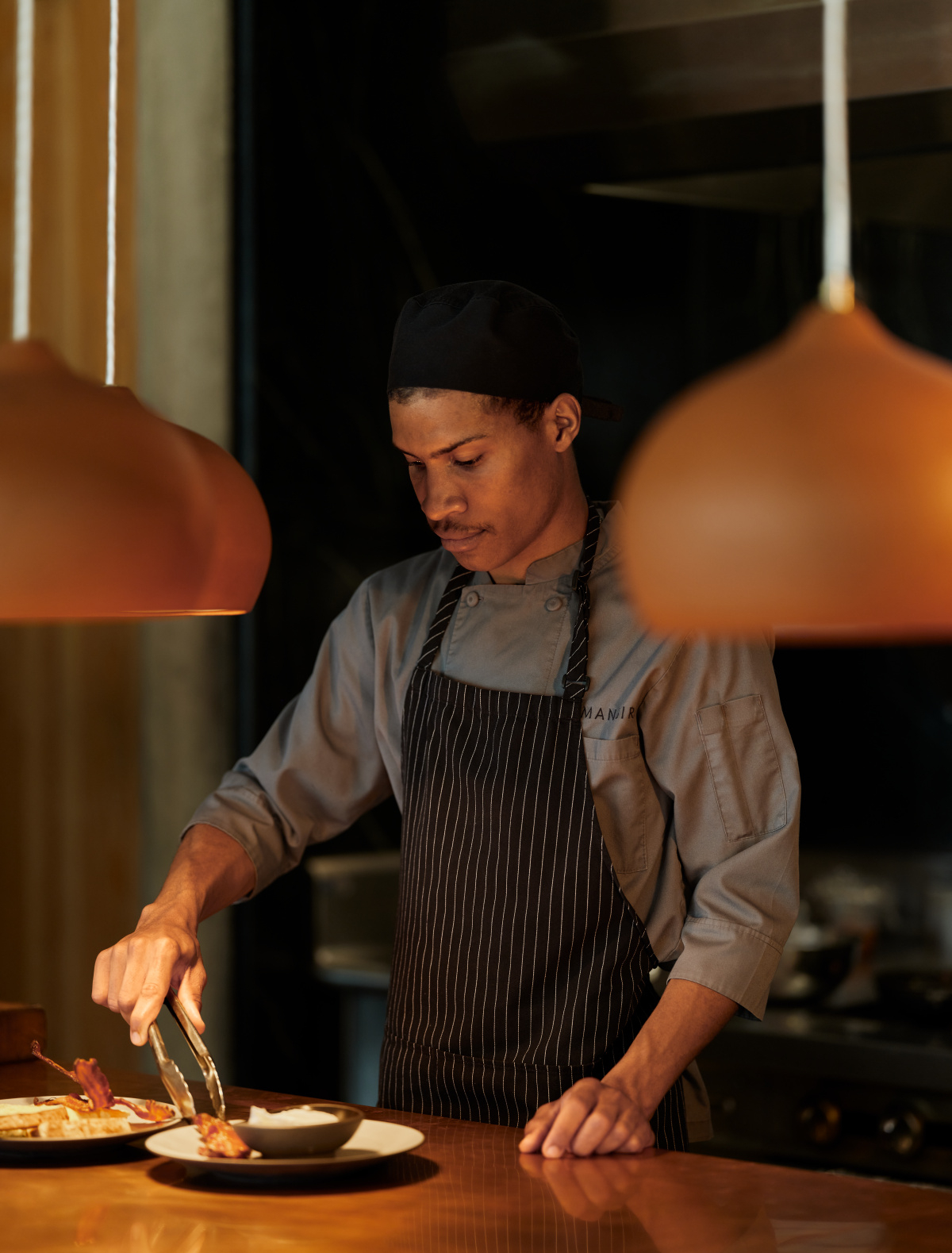 A chef adds the final touches to a dish in the open kitchen at Camp Sarika's dining pavilion at Amangiri.