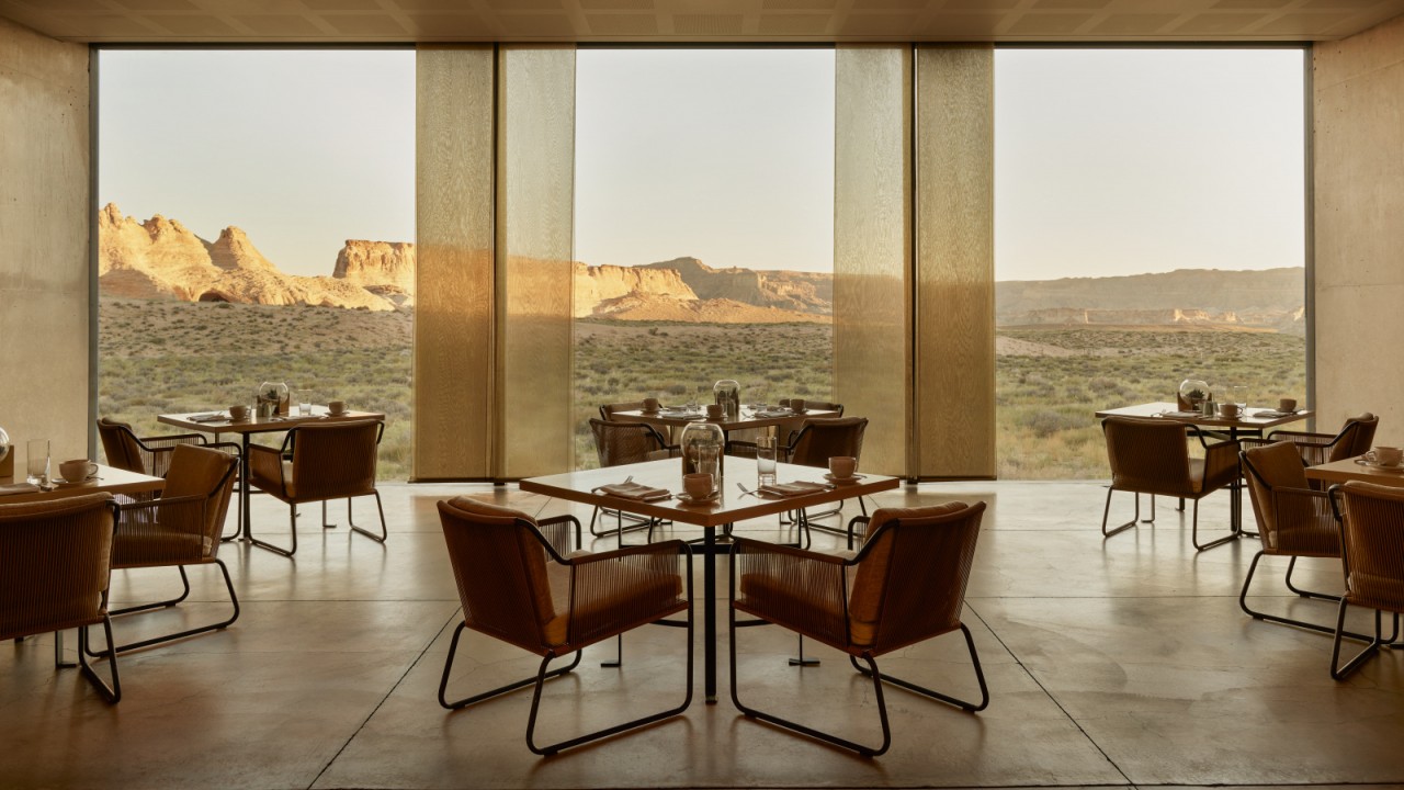 The elegant interior of the Amangiri Resort restaurant with floor-to-ceiling windows offering panoramic desert views.