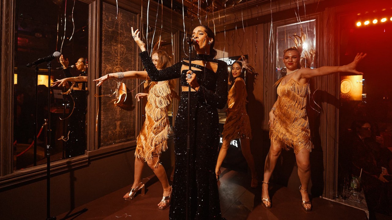 A vibrant singer and dance crew performing on stage during the exclusive New Year's Eve party at BLING nightclub.