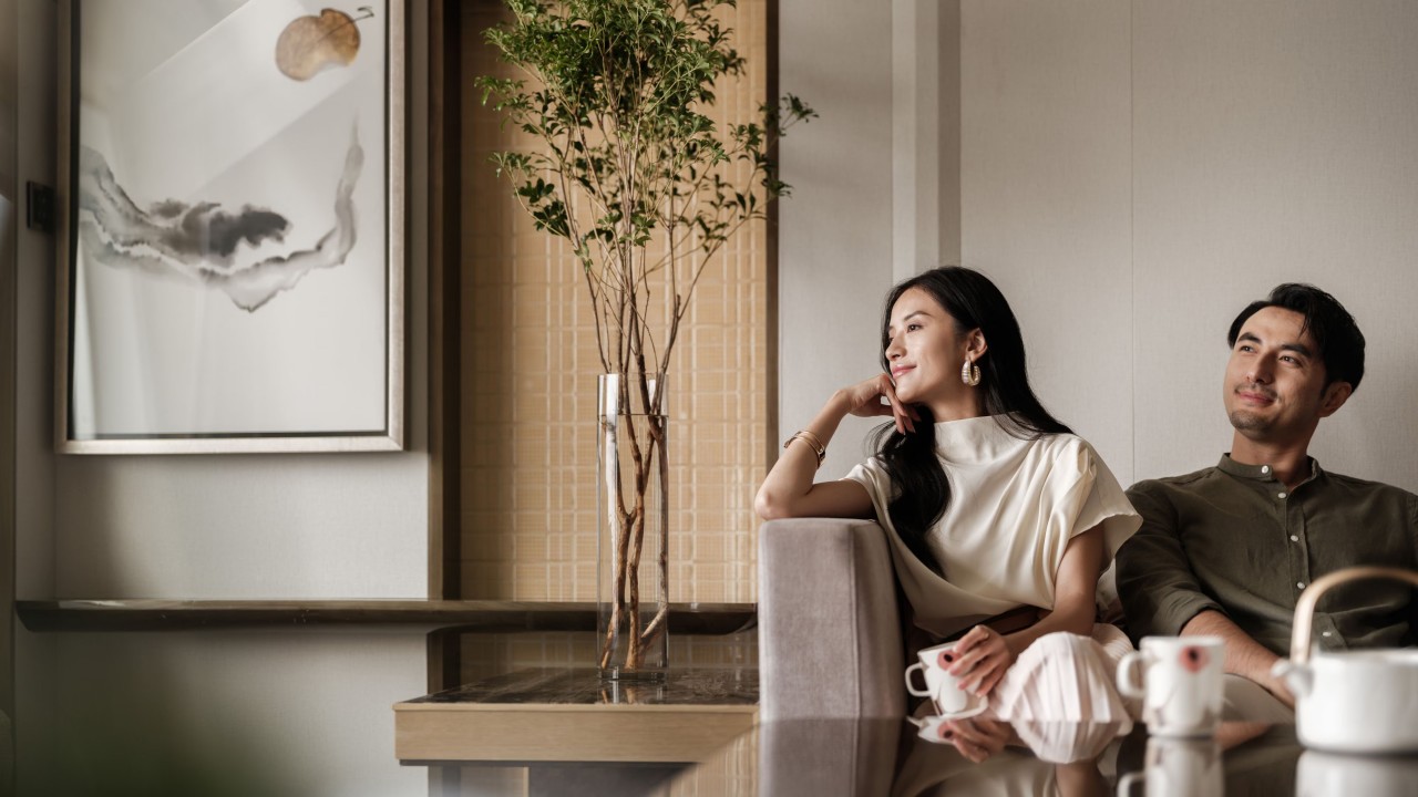 A couple enjoys the vibrant and joyful ambiance of the "Blissful Stay with Marimekko" themed room at JW Marriott, featuring the brand's iconic bold prints.