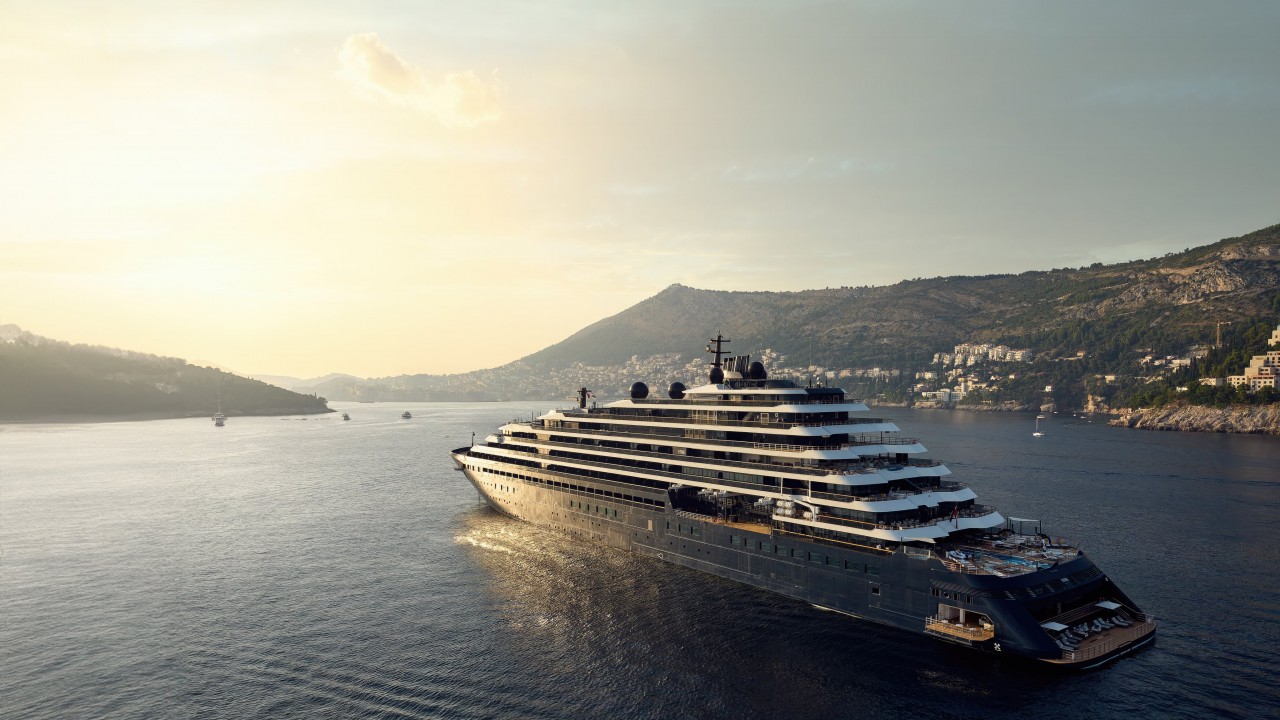 The luxury yacht Evrima from The Ritz-Carlton Yacht Collection gracefully sailing on calm blue waters.