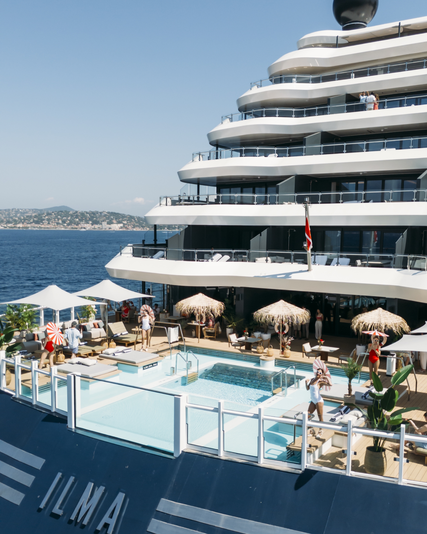 Guests relaxing by the serene aft pool aboard the Ilma superyacht, enjoying the panoramic sea views.