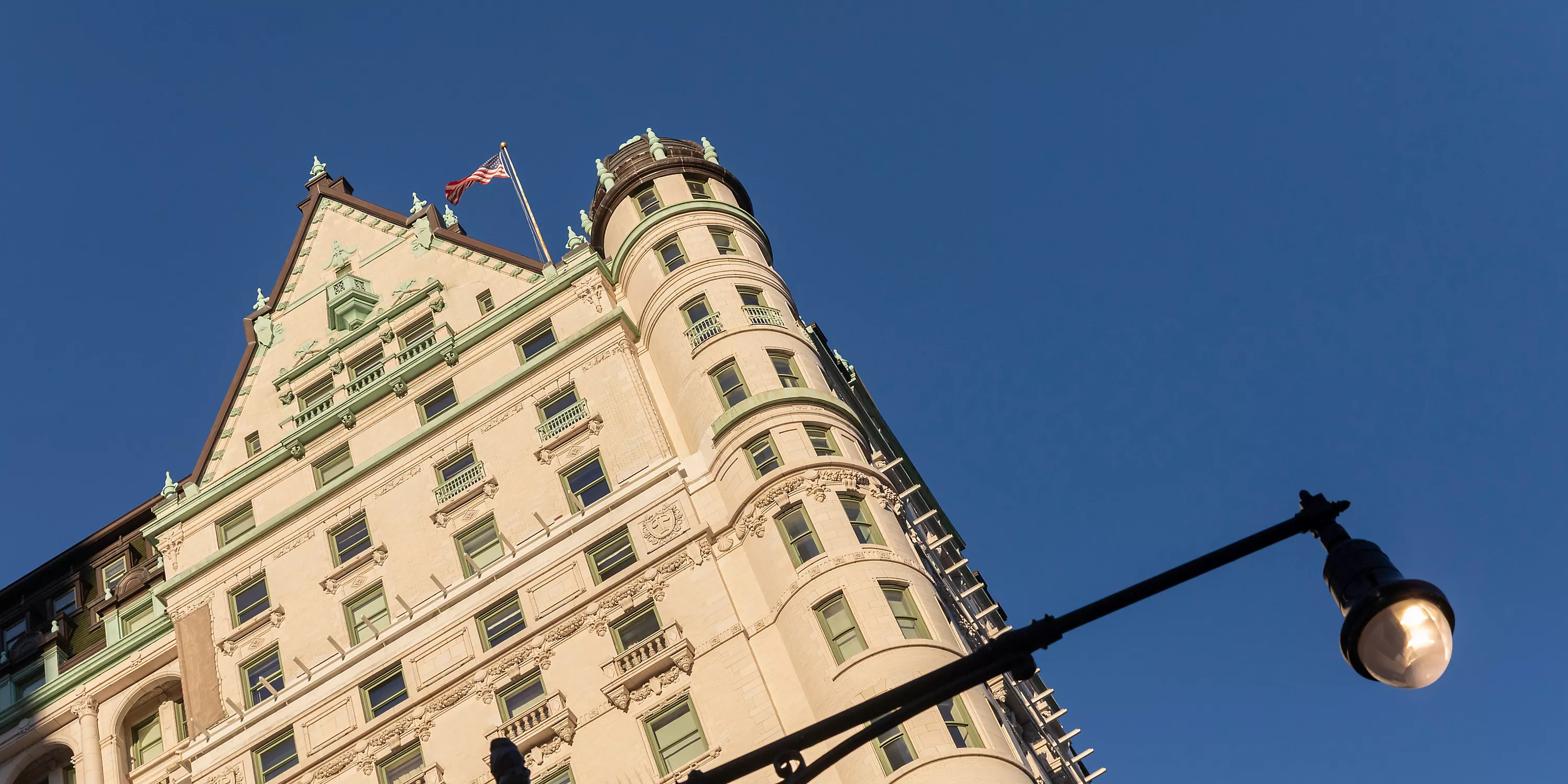 A detailed shot of the iconic Plaza Hotel's exterior on Fifth Avenue, showcasing its elegant Beaux-Arts architecture, intricate stonework, and ornate windows.